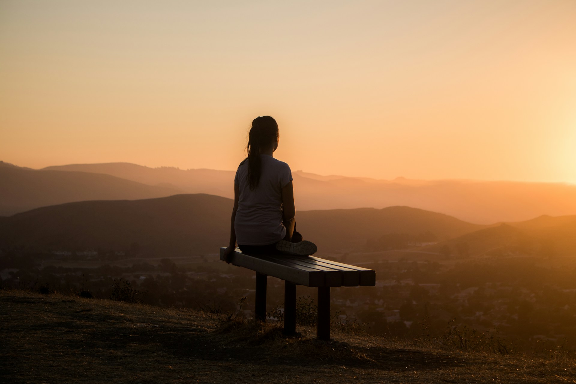 a woman doing meditation in sunset